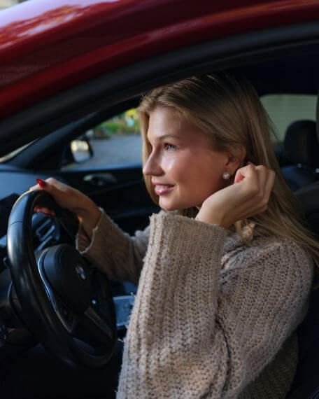 Kissanmaan Autokoulu Tampere – nuori nainen istuu punaisen auton ratissa